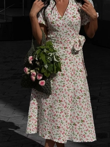 Close-up of floral cotton wrap dress with puff sleeves and waist tie detail