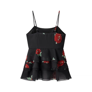 Detailed close-up of black floral top featuring red rose print and ruffled chiffon layers