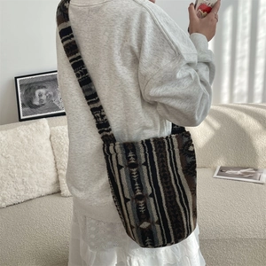 Close-up of bohemian geometric striped plush shoulder bag texture on model