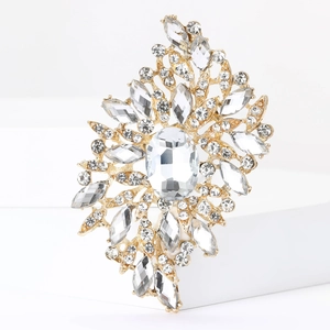 Detailed close-up of an ornate gold brooch featuring sparkling rhinestones and crystals