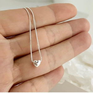 Macro shot of 925 sterling silver heart pendant necklace on a fine box chain