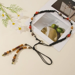 Detail of bohemian braided waist chain with colorful beads and small bronze bells