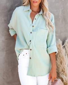Detail of light green cotton linen shirt featuring v-neck buttons and chest pocket