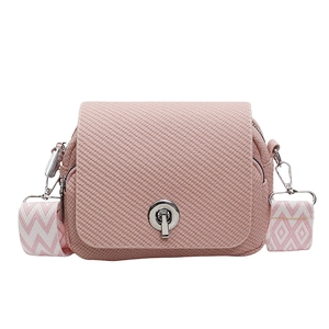 Stylish pink textured mini crossbody bag featuring a chic turn-lock closure and wide strap.