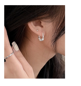 Close-up of S925 sterling silver geometric hoop earrings and engraved IN TIME ring on model