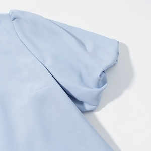 Detailed macro view of light blue puff sleeves with elegant pleated fabric textures