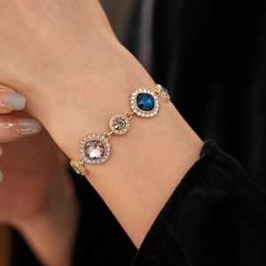 Close-up of vintage gold bracelet with multi-color crystals and pave diamond details