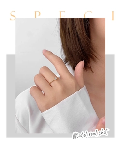Close-up of minimalist four-prong cubic zirconia ring on finger with gold plating