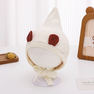 Detail of knit baby elf hat in beige with pointed top and contrast brown ears