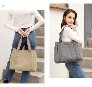 Lifestyle shot of large canvas tote bags in khaki and gray shown on a staircase