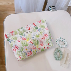 Detail view of floral print cotton makeup bag with simple wish label and hair accessories