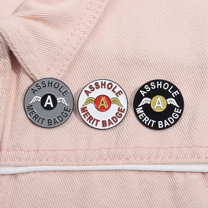 Gros plan détaillé de trois badges émaillés sur un fond de tissu en denim rose vif