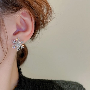 Close-up side view of a model wearing sparkling zircon snowflake pearl stud earrings
