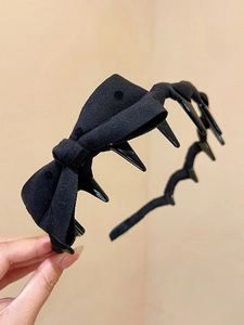 Close-up of black bow headband featuring built-in inner teeth for secure hair styling