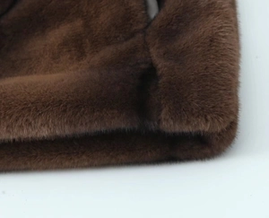 Close-up of dark brown faux fur texture and smooth leather patchwork on the mini skirt