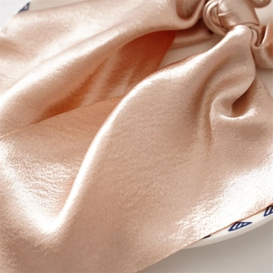 Elegant champagne satin silk scrunchie with smooth ribbon texture for women hairstyles
