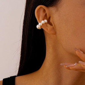 Close-up of minimalist C-shaped ear cuff with four glossy white pearls on a model
