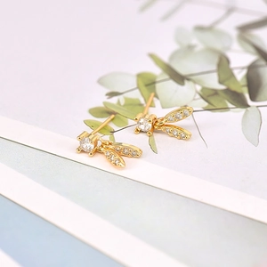 Elegant gold leaf earrings with round zircon stones on a decorative card display
