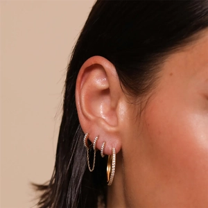 Close-up of four-piece gold plated S925 silver hoop earrings set with zircon stones on ear