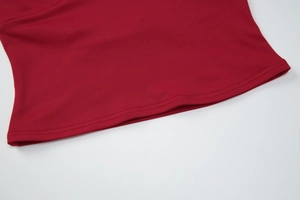 Dettaglio del top in maglia rossa che mostra il tessuto elastico e la cucitura a doppio ago