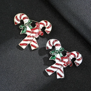 Zwei weihnachtliche Zuckerstangen-Broschen mit rot-weißen Streifen auf schwarzem Hintergrund
