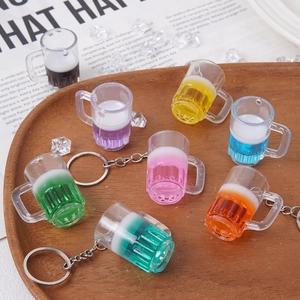 Mini porte-clés en forme de chope de bière colorée sur un plateau en bois avec glace