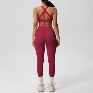Detail of high-waist yoga leggings and cross-back sports bra in deep rose pink