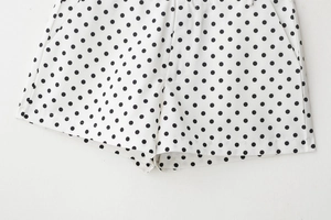 Gros plan détaillé du short à pois blancs et noirs avec fermeture éclair et poches latérales