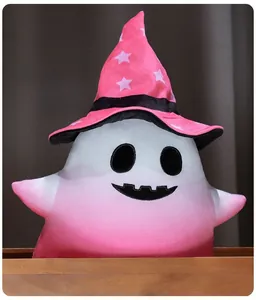 Detail of cute pink gradient Halloween ghost plush toy wearing a wizard hat on wood