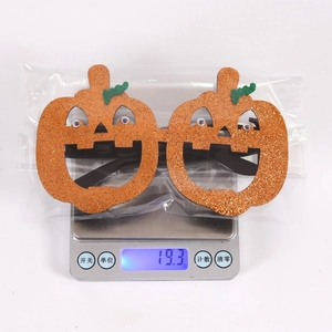 Detail of glitter pumpkin Halloween glasses on a scale showing 19.3g weight