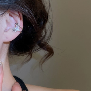 Macro shot of silver star-shaped ear cuff featuring double layers and white zircons