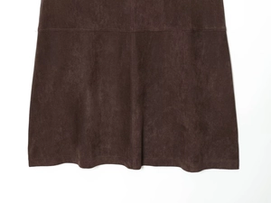Gros plan détaillé sur le tissu en daim marron de la jupe midi avec double couture robuste