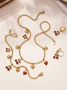 Détail de parure bijoux bracelet en acier inoxydable doré PVD avec cerise et cœur