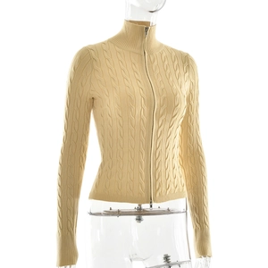 Détail de la maille torsadée et de la fermeture éclair sur ce pull beige ajusté