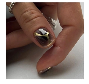 Macro shot of dark brown nails with golden geometric lines and fine shimmer details