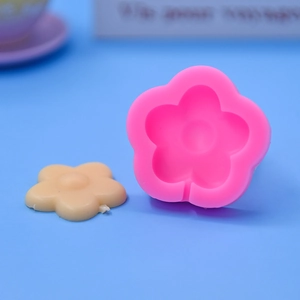 Pink silicone flower lollipop mold for DIY baking and cake decoration on blue background