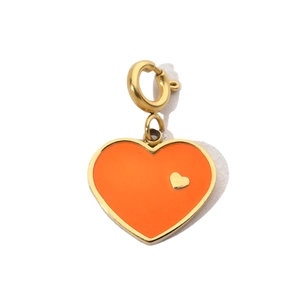 Macro detail of orange heart charm with gold rim and spring clasp for jewelry