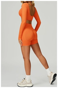 Detail view of seamless high-waist orange yoga shorts with a curved lifting seam design