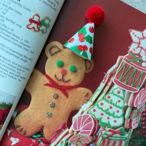 Macro shot of bear gingerbread cookies with festive icing on a vintage recipe book background