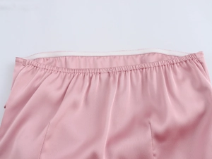Détail de la taille en tissu satiné rose montrant la bande élastique et la texture