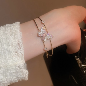 Close-up of double-layer zircon butterfly bangle on a model with white lace sleeve