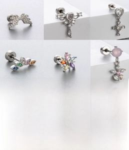 Macro shot of silver titanium steel cartilage studs with zircon stars and heart shapes