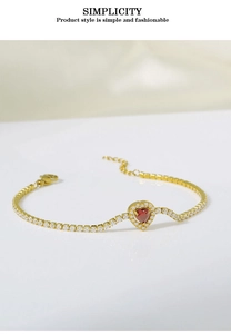 Macro view of heart-shaped red gemstone bracelet with golden finish and white zircons