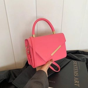 Retro pink crossbody handbag with gold hardware detail and textured leather finish