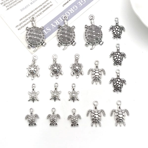 Flat lay of vintage silver turtle charms in various sizes for DIY jewelry making