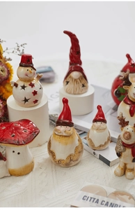 Detail of illuminated ceramic Christmas ornaments featuring snowmen and reindeer on a table
