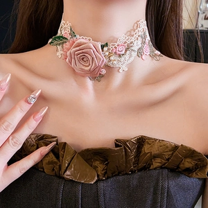 Close-up of pink fabric rose and pearls on a beige lace choker worn by a model