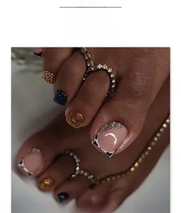 Detail of blue glitter toe nails with 3D crystal accents and amber spiral patterns