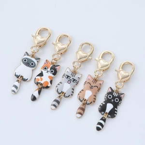 Set of five cartoon cat keychains with gold heart clasps and swinging tails in enamel finish