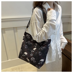 Close-up of skull and floral print canvas tote bag with ethnic style wide shoulder strap